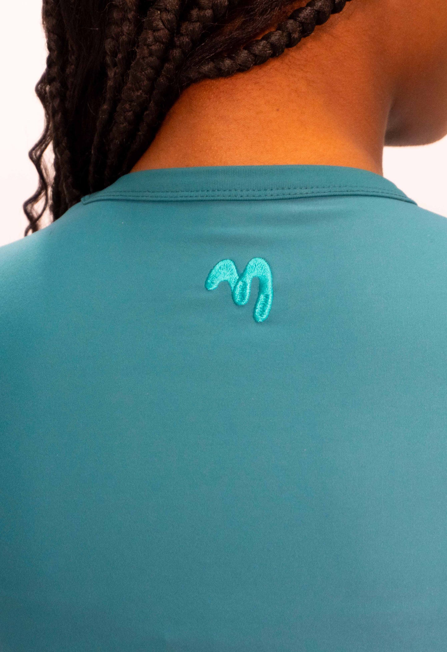 Close-up green sports t-shirt with embroidered logo on the back.