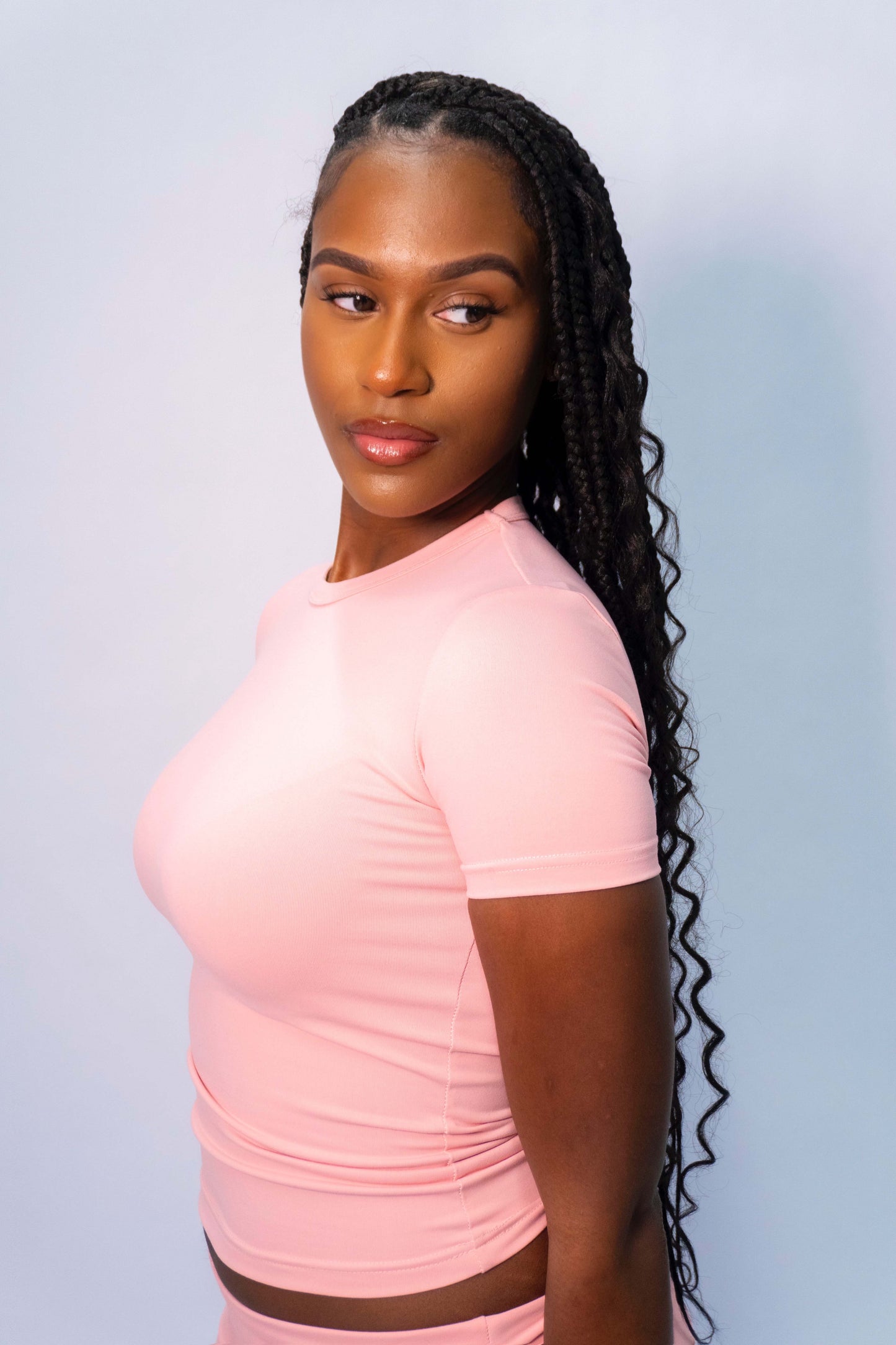 Woman wearing a pink fitted short sleeve T-shirt.